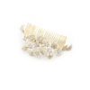 Gold and white Coraline Comb adorned with delicate flowers, set against a Chicago