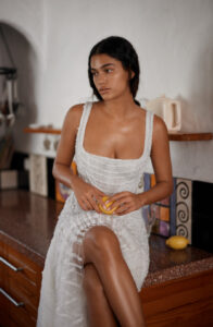 Dana Harel Jolene Wedding Dress from a bridal shop in Chicago, IL. The model is holding a lemon and sitting on a kitchen countertop.