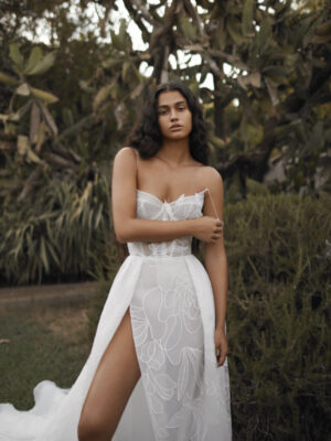 A model pouts and pulls at her spaghetti strap wearing a Dana Harel Kim wedding dress from a bridal shop in Chicago, IL.