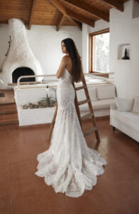 Dana Harel Venice Wedding Dress from a Bridal Shop in Chicago, IL. The model is posing in front of a wood burning fire place next to a ladder.