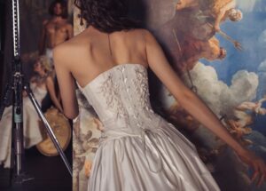 A closeup of the back of a model wearing an Isabelle wedding dress by Kim Kassas. The corset has pearl embellishments. Available at a bridal shop in Chicago, IL.