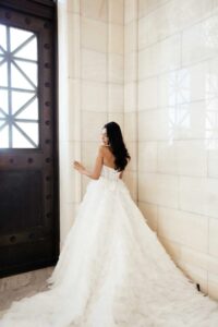 Martina Liana 1629 Wedding dress is an extravagant tulle bridal gown featuring tiers of delicate ruffles and a dramatic train at a bridal shop in Chicago, IL