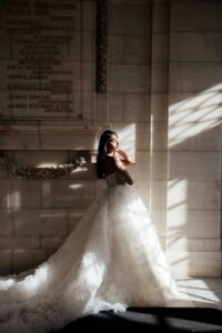 Martina Liana 1629 Wedding Dress is an extravagant tulle bridal gown featuring tiers of ruffles and a dramatic train at a bridal shop in Chicago, IL