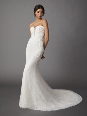 Full-length front view of a model wearing an elegant Chantilly lace fit and flare gown that features a sweetheart plunge neckline and delicate floral beading from a bridal shop in Chicago, IL.