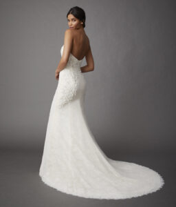 Back view of a model wearing an elegant Chantilly lace fit and flare gown that features a sweetheart plunge neckline and delicate floral beading from a bridal shop in Chicago, IL.