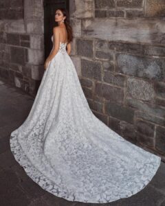 A model shows the open back and train of her whimsical A-line gown, Callista by Calla Blanche, with lace detailing from a bridal shop in Chicago, IL.