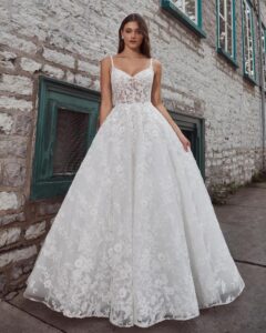 A bride shows her wedding dress Krishna by Calle Blanche in Chicago, IL. It is an enchanting ballgown with romantic floral lace, a sweetheart neckline, and an elegant open back.