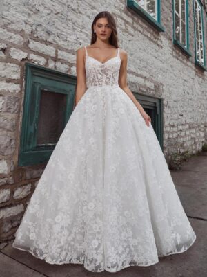 A bride shows her wedding dress Krishna by Calle Blanche in Chicago, IL. It is an enchanting ballgown with romantic floral lace, a sweetheart neckline, and an elegant open back.