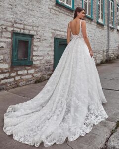 A bride shows the back of her wedding dress Krishna by Calle Blanche in Chicago, IL. It is an enchanting ballgown with romantic floral lace, a sweetheart neckline, and an elegant open back.