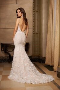 A model shows the back of her 5056 by Paloma Blanca wedding dress which is an ethereal bridal gown that features intricate 3D lace, draped in natural and blush Italian tulle. It's completed with a charming scoop neckline and a low open back and is available at a bridal shop in Chicago, IL.