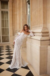 A model wears the Ellie by Eisen Stein wedding dress which is a Strapless fitted sequin dress with an elegant fold-over and is available at a boutique in Chicago, IL.