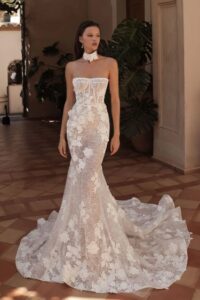 A bride shows the front of her wedding dress, Rania by Eden Aharon. The strapless fit and flare bridal gown features 3D floral appliques. See it at a bridal shop in Chicago, IL.