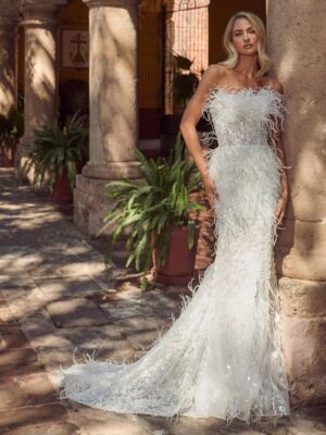 Fitted wedding gown with feathers and a strapless neckline. 