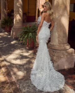 Fitted wedding gown with feathers and a strapless neckline. 