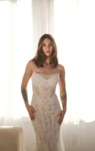 A close-up view of a bride wearing the 1752 wedding dress by Martina Liana. It is a lace bridal gown with a sweetheart neckline and sheer strapless bodice. The fit and flare silhouette is shown without the detachable off-the-shoulder long lace sleeves. It is available at a bridal shop in Chicago, IL.