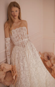 Off-the-shoulder wedding gown with sheer, long sleeves and Basque waist.