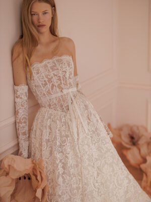 Off-the-shoulder wedding gown with sheer, long sleeves and Basque waist.