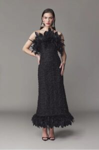 Strapless evening gown with feathers on bodice and hem.