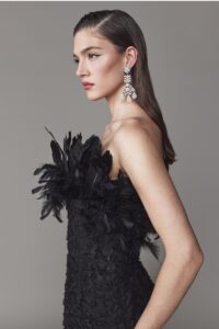 Strapless evening gown with feathers on bodice and hem.