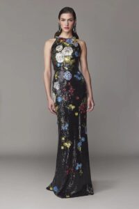 Halter gown with a fit and flare skirt silhouette. This evening gown is completed with stunning floral detailing. 