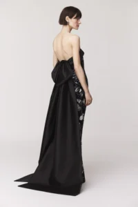 Strapless gown Contrast satin organza collar band with back bow and train Column skirt silhouette with back slit Exposed back zipper Satin lined