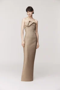 Strapless gown Bodice with sculptural draping Column skirt silhouette with back slit Exposed back zipper Satin lined