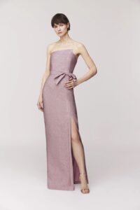 Strapless gown Bodice with assemetrical seaming detail and front side bow Column skirt silhouette, front slit with seaming detail Exposed back zipper Satin lined