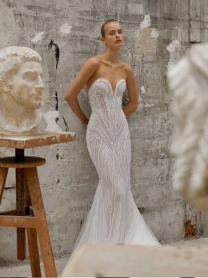 Mermaid gown crafted from a pearl fabric, uniquely designed to layer in intricate formations that flatter the figure, featuring a plunging sweetheart neckline and a train extension.