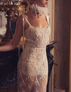 Lace wedding gown with sheer beaded skirt and bow detailing.