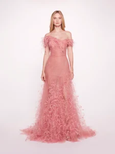 This stunning gown features a vibrant flamingo pink hue, elegantly crafted from soft tulle. The off-the-shoulder design adds a touch of romance, while delicate feather accents enhance the overall whimsy. The flattering A-line silhouette flows gracefully, making it perfect for any special occasion. Experience the perfect blend of elegance and playful charm in this exquisite piece.