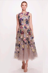 A beautiful tulle midi dress featuring a jewel neckline with 3 dimensional floral detailing and a pleated A-line skirt