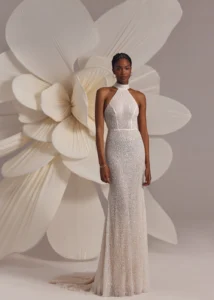 Ivory halterneck beaded dress with natural waistline and straight silhouette, featuring open back.