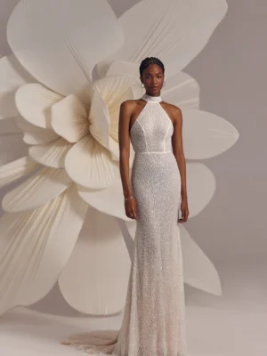 Ivory halterneck beaded dress with natural waistline and straight silhouette, featuring open back.