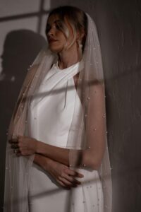 Our Pearl Veil features a single layer, 3-meter cathedral-length design adorned with delicate pearl detailing. It comes attached to a comb, making it effortless to secure in your hair.