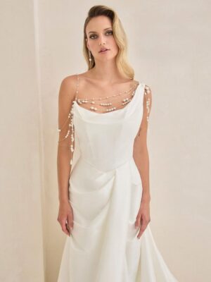 Bridal gown with asymmetrical neckline and pearl detailing.