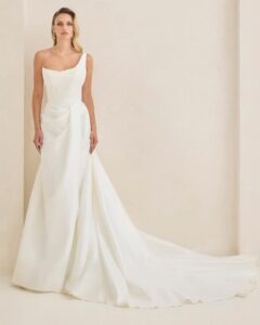 Bridal gown with asymmetrical neckline and pearl detailing.