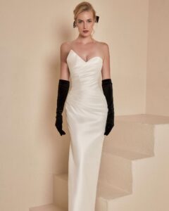 An asymmetrical strapless wedding gown with elegant draped detailing.