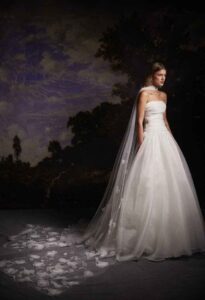 A woman in a wedding dress stands gracefully in front of a large, colorful painting in Chicago