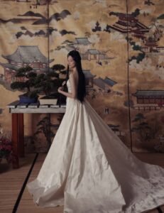 A bride poses in the Chiyo wedding dress by Kim Kassas, set against a large painting in Chicago.