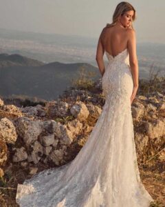 Back view of a model posing in Donica by Calla Blanche, a strapless lace wedding dress in Chicago.