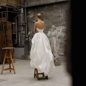 Back view of a woman standing on a stool in an industrial-style room in Chicago, IL.