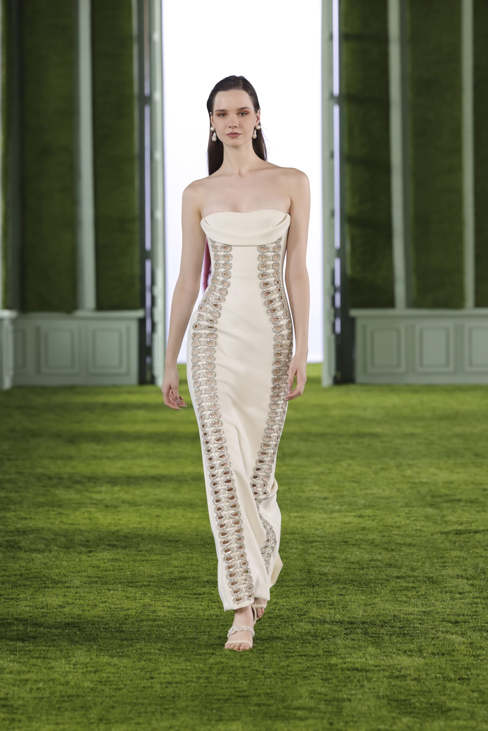 Strapless cream dress with a double row of beautifully aligned crystalized bow cut outs. Available at Mira Couture in Chicago