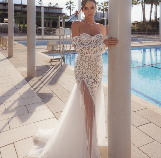 A bride shows the front of her wedding dress