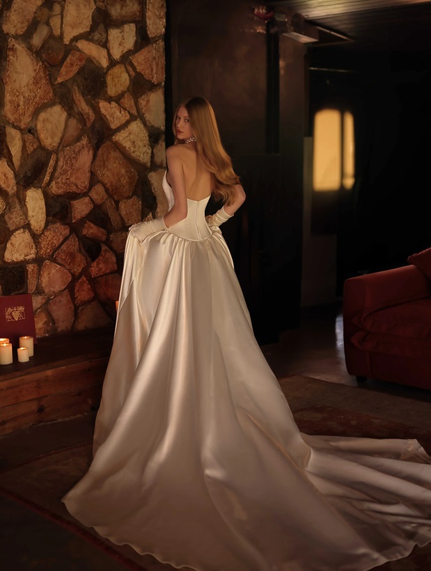This chic ballgown features a scoop neck and a pointed silky corset with a dropped waist