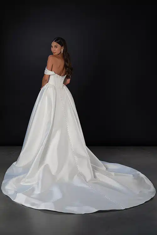 Martina Liana satin wedding dress with a full train and elegant buttons. Available at Mira Couture in Chicago